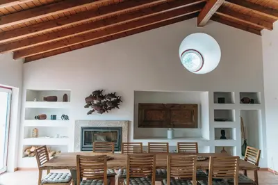 a dining room with a table and chairs and a fireplace at Casa Nook Arrifana in Aljezur