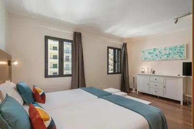 a bedroom with a large white bed and windows at Apartamento na Praça by An Island Apart in Funchal