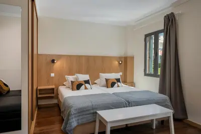 a bedroom with a large bed and a table at Apartamento na Praça by An Island Apart in Funchal