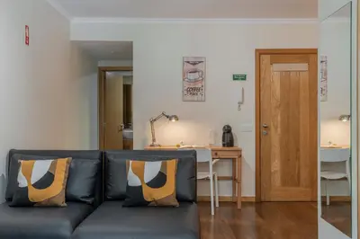 a living room with a blue couch with two pillows at Apartamento na Praça by An Island Apart in Funchal
