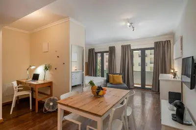a living room with a wooden table and a desk at Apartamento na Praça by An Island Apart in Funchal