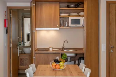 a kitchen with a table with a bowl of fruit on it at Apartamento na Praça by An Island Apart in Funchal