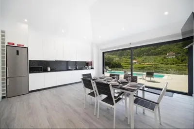 a kitchen and dining room with a table and chairs at Casa Avô da Pedra, By OP in São Vicente