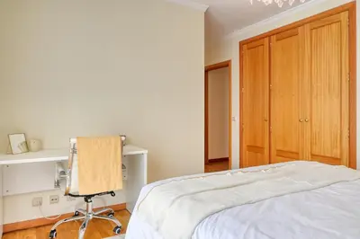 a bedroom with a bed and a chair in it at Costa do Sol, a Home in Madeira in Funchal