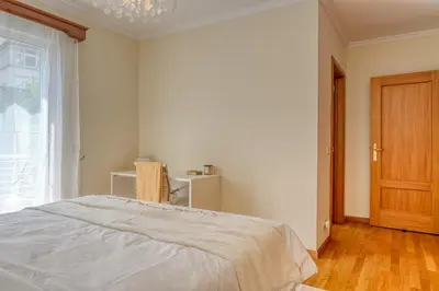 a white bedroom with a bed and a window at Costa do Sol, a Home in Madeira in Funchal