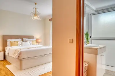 a bedroom with a bed and a bathroom at Costa do Sol, a Home in Madeira in Funchal