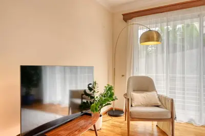 a living room with a tv and a chair at Costa do Sol, a Home in Madeira in Funchal
