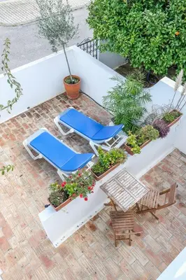 a group of lounge chairs and tables on a patio at Casa Azure in Luz