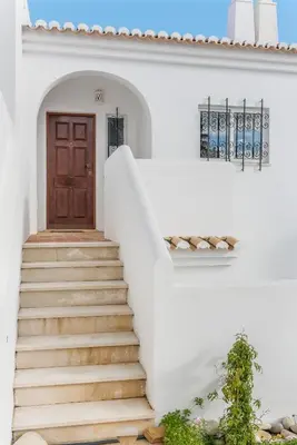 a staircase leading to a door in a white house at Casa Azure in Luz