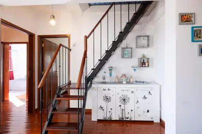 a staircase in a living room with a white wall at Terrace to Atlantic in Santa Cruz