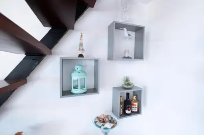 a wall with three shelves with a blue bottle on it at Terrace to Atlantic in Santa Cruz