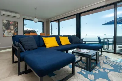 a living room with a blue couch and yellow pillows at Elísio do Mar by LovelyStay in Prazeres