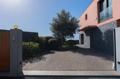 a driveway in front of a building with a tree at Elísio do Mar by LovelyStay in Prazeres