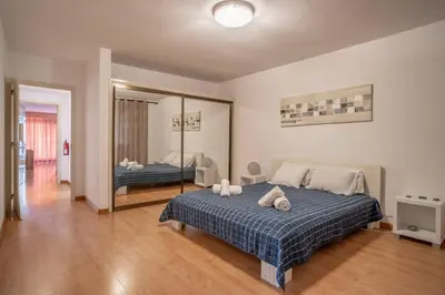 a bedroom with a large bed and a large mirror at Atlantic Garden Front Praia Formosa in Funchal