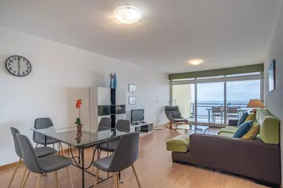 a living room with a couch and a table and chairs at Atlantic Garden Front Praia Formosa in Funchal