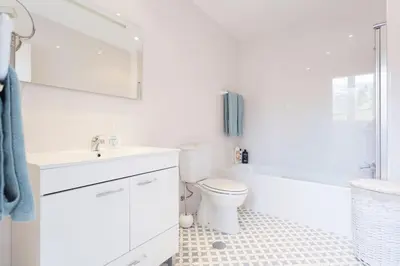 a white bathroom with a toilet and a sink at Casa Primavera - renovated duplex in city centre in Funchal