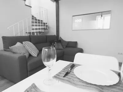 a living room with a table with a wine glass at Casa Primavera - renovated duplex in city centre in Funchal