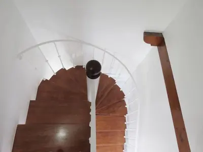 a spiral staircase with a wooden stair case at Casa Primavera - renovated duplex in city centre in Funchal