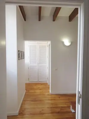 an empty room with white walls and wood floors at Casa Primavera - renovated duplex in city centre in Funchal
