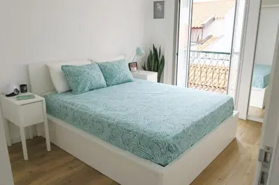 a bed with a blue comforter in a room with a window at Apartment Primavera: City centre, modern w/balcony in Funchal