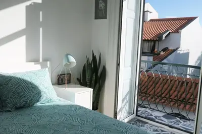 a bedroom with a bed and a balcony with a window at Apartment Primavera: City centre, modern w/balcony in Funchal