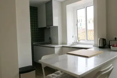 a white kitchen with a table and a window at Apartment Primavera: City centre, modern w/balcony in Funchal