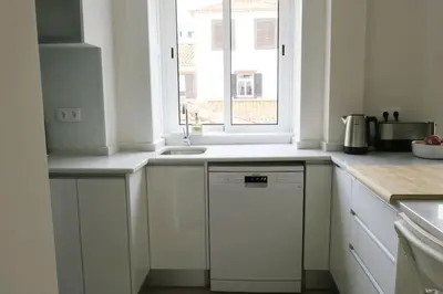 a white kitchen with a dishwasher and a window at Apartment Primavera: City centre, modern w/balcony in Funchal