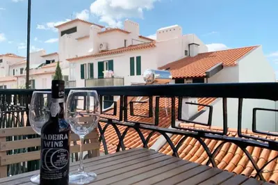 a bottle of wine sitting on a wooden table on a balcony at Apartment Primavera: City centre, modern w/balcony in Funchal