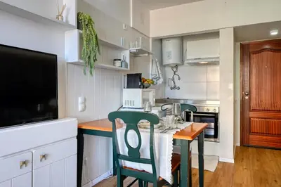 a kitchen with a table with chairs and a television at Blue Wave, a Home in Madeira in Funchal