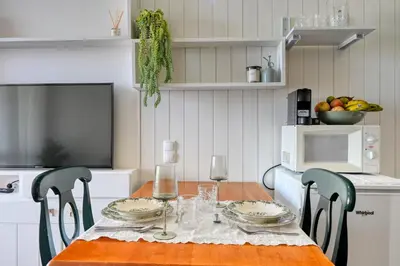 a dining room table with two chairs and a table with wine glasses at Blue Wave, a Home in Madeira in Funchal