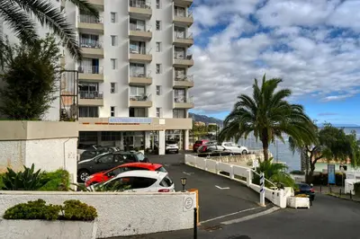 a parking lot with cars parked in front of a building at Blue Wave, a Home in Madeira in Funchal