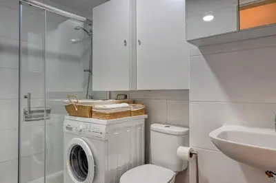 a bathroom with a washing machine and a sink at Blue Wave, a Home in Madeira in Funchal