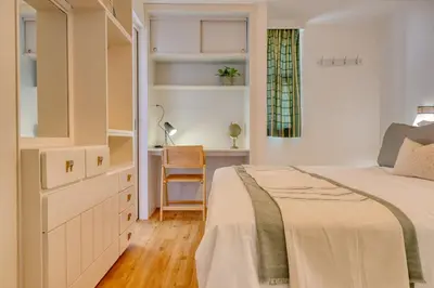 a white bedroom with a bed and a desk at Blue Wave, a Home in Madeira in Funchal