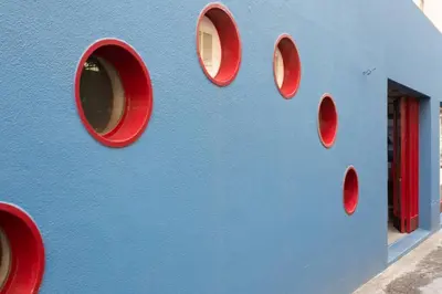 a blue wall with red windows on a building at Apartment Banana Panorama: central Lido area in Funchal