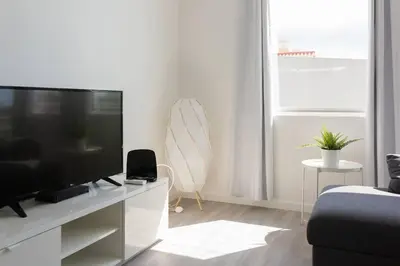 a living room with a flat screen tv on a white cabinet at Apartment Banana Panorama: central Lido area in Funchal
