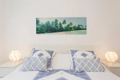 a bedroom with a bed with blue and white pillows at Apartment Banana Panorama: central Lido area in Funchal