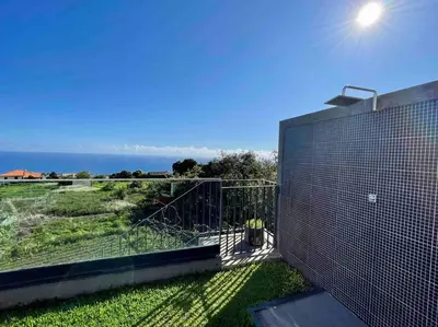 a view of the ocean from the balcony of a house at Panoramic View: Lux 3 bed with heated pool in Arco da Calheta