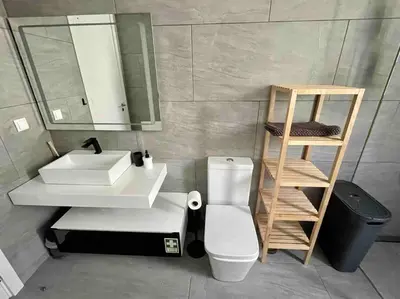 a bathroom with a sink and a toilet and a mirror at Panoramic View: Lux 3 bed with heated pool in Arco da Calheta