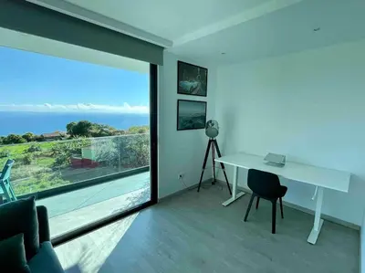a white desk in a room with a large window at Panoramic View: Lux 3 bed with heated pool in Arco da Calheta