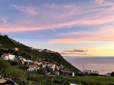 a group of houses on a hill next to the ocean at Panoramic View: Lux 3 bed with heated pool in Arco da Calheta