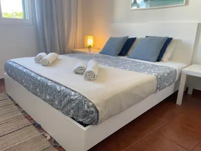 a bedroom with a large bed and a window at SandyBeachApartment in Porto Santo
