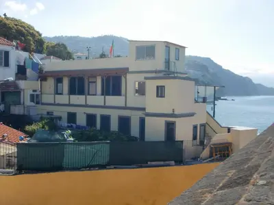 a white house on a hill next to the ocean at Casa Zona Velha - Caetano in Funchal