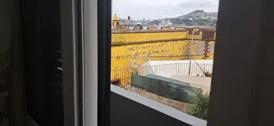 a view of a yellow wall from a window at Casa Zona Velha - Caetano in Funchal