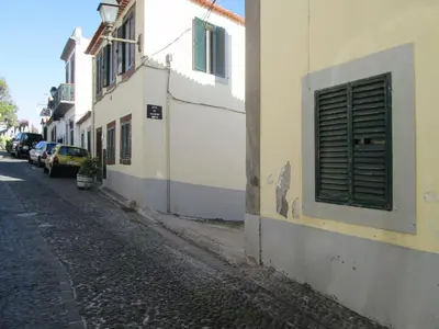 a building with a window and a street with cars at Casa Zona Velha - Caetano in Funchal