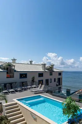 a house with a swimming pool next to the ocean at Mediterrâneo Madeira in São Vicente