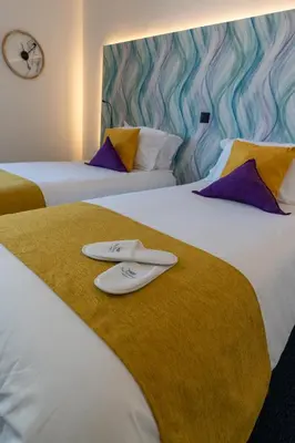 two beds in a hotel room with two surfboards on them at Mediterrâneo Madeira in São Vicente