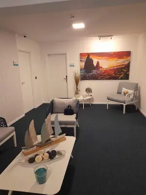 a waiting room with couches and tables and a painting at Mediterrâneo Madeira in São Vicente