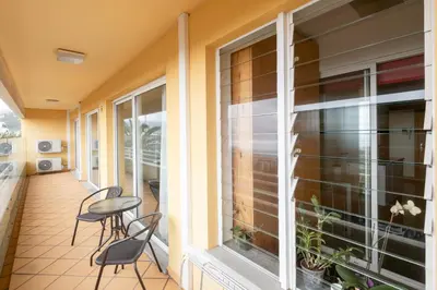 a balcony with chairs and a table and windows at By the Sea II - calmo com piscina e vista mar. in Funchal