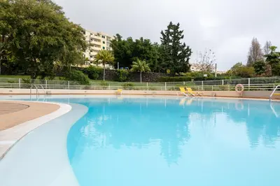 a large swimming pool with blue water at By the Sea II - calmo com piscina e vista mar. in Funchal