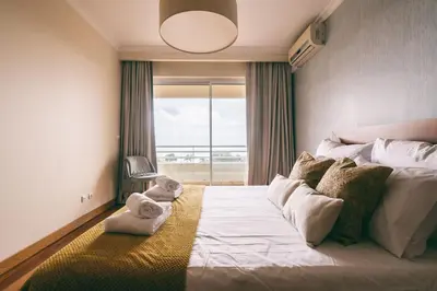 a bedroom with a bed with a teddy bear on it at By the Sea II - calmo com piscina e vista mar. in Funchal